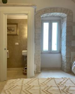 a bathroom with a window and a sink in a room at Mazzini 5 in Locorotondo