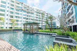 a swimming pool in front of a large building at Centrio Phuket C3 in Ban Rangeng
