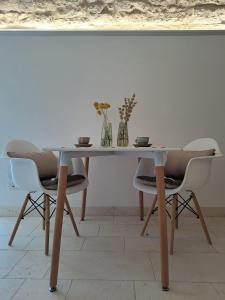 a table with two chairs and two vases on it at Mazzini 5 in Locorotondo +21 photos