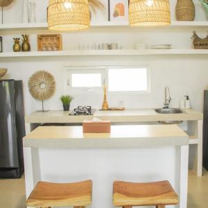une cuisine avec un comptoir et deux tabourets en bois dans l'établissement Dry Villa, à Jarakan