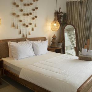 un lit avec des draps blancs et des oreillers dans une chambre dans l'établissement Dry Villa, à Jarakan