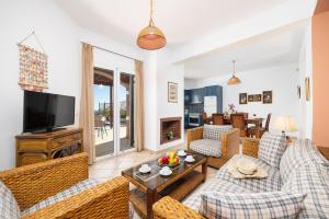 a living room with couches and a television at Villa Thalia Katerina in Mousata