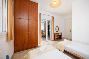 a bedroom with two beds and a wooden cabinet at Villa Thalia Katerina in Mousata +42 photos