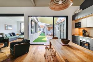 a kitchen and living room with a wooden table at Maison 4 chambres avec piscine in Le Château-dʼOléron