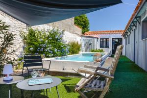 a patio with chairs and a swimming pool at Maison 4 chambres avec piscine in Le Château-dʼOléron