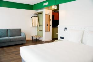 巴黎All Suites Appart Hôtel et Hôtel - Paris 13 - Porte d'Italie的一间带一张床和一张沙发的房间以及一间带床的房间