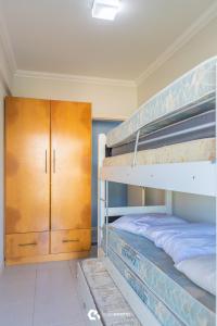 1 Schlafzimmer mit 2 Etagenbetten und einem Holzschrank in der Unterkunft 150m do mar! Cobertura Duplex com Piscina Privada in Bombinhas
