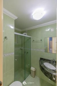 ein Badezimmer mit Glasdusche und Waschbecken in der Unterkunft 150m do mar! Cobertura Duplex com Piscina Privada in Bombinhas