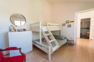 a bedroom with two bunk beds and a mirror at La Maison Château d'Eau : piscine pour 6/8 pers in Saint-Benoît +35 photos