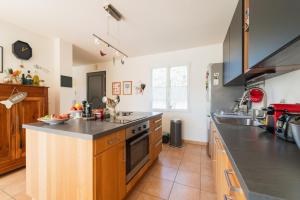 a large kitchen with a counter and a sink at La Maison Château d'Eau : piscine pour 6/8 pers in Saint-Benoît