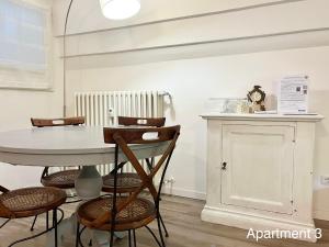 tavolo e sedie in una stanza con orologio appeso a un muro di MeModena Apartments a Modena Altre 21 foto
