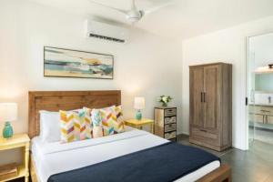 a bedroom with a large bed and a cabinet at Grace Bay Vacation Villa in Long Bay Hills