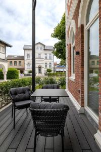 a patio with a table and chairs on a deck at Apartments Hotel Stadt Hamburg in Westerland (Sylt)