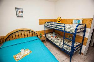 1 dormitorio con 2 literas con sábanas azules en Quiet little villa by the seaside in Rosolina Mare, en Rosolina Mare