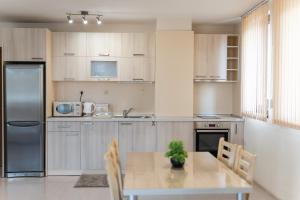 a kitchen with a table with chairs and a refrigerator at Апартамент АВА in Sandanski