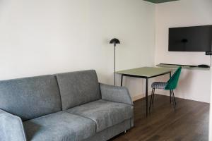 巴黎All Suites Appart Hôtel et Hôtel - Paris 13 - Porte d'Italie的带沙发和桌子的客厅