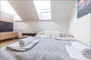 um quarto com uma cama grande com toalhas em Minimalist's Dream - sunny cozy studio in New Town em Praga