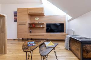 uma sala de estar com uma TV e uma mesa em Minimalist's Dream - sunny cozy studio in New Town em Praga