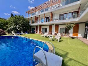 a hotel with a swimming pool in front of a building at Kiara Apartments in Saints Constantine and Helena