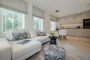 a living room with a white couch and a kitchen at Apartments Hotel Stadt Hamburg in Westerland (Sylt)