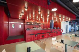 巴黎All Suites Appart Hôtel et Hôtel - Paris 13 - Porte d'Italie的餐厅拥有红色的墙壁和桌椅
