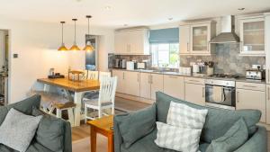 a kitchen and living room with a table and chairs at Derwentwater View in Portinscale