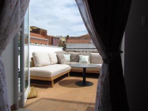 a living room with a couch and a table on a balcony at Casa Portao da Cidade in Silves
