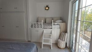 a white room with a shelf and a bed at Feraklion House in Haraki