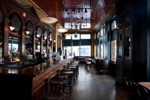 a bar with chairs and a long counter in a restaurant at Kellys Hotel in Dublin