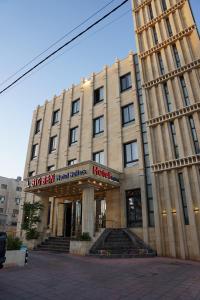 a large building with a hotel in front of it at Big Ben Hotel Suites in Amman