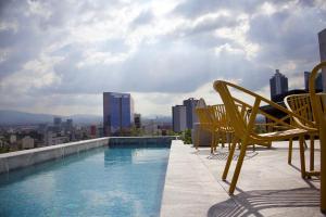 a swimming pool on the roof of a building at Luxury Apartment in Roma Norte With Stunning Views in Mexico City +3 photos
