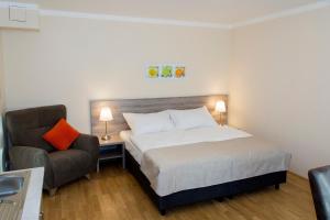 Habitación de hotel con cama y silla en Limes Apartments en Praga