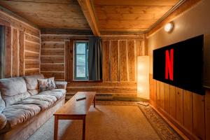 a living room with a couch and a x on the wall at Ancestral Wooden Chalet - St-Gabriel de Brandon in Mandeville