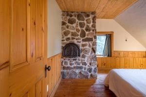 a bedroom with a stone wall next to a bed at Ancestral Wooden Chalet - St-Gabriel de Brandon in Mandeville
