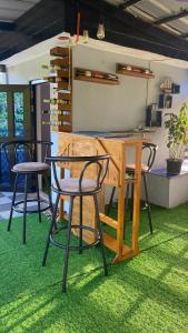 a table and four chairs sitting in a room with grass at Aliyah Transient House in Atimonan