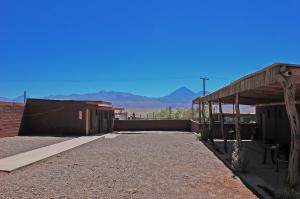 un bâtiment dans le désert avec des montagnes en arrière-plan dans l'établissement Hostal Mirador, à San Pedro de Atacama
