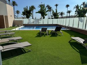 a swimming pool with lawn chairs and a swimming pool at Casa Virginia in Los Alcázares