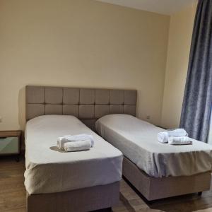 two beds in a bedroom with towels on them at guest house MyOni in Oni