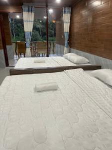 two large white beds in a room at Green Bamboo Lodge Resort in Cat Tien