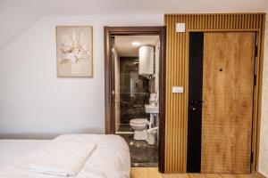 a bedroom with a bed and a bathroom with a toilet at Hotel Mažijanik in Nikšić +137 photos