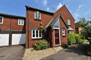 a red brick house with a white garage at Warfield Charming Three Bedroom House in Warfield
