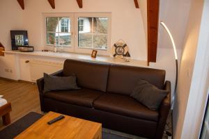a living room with a brown couch and a table at Appartement Achtern Diek 2-23 in Dorum-Neufeld