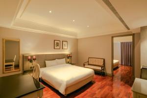 a bedroom with a bed and a chair and a mirror at Rhyme&Time Hotel in Kaohsiung