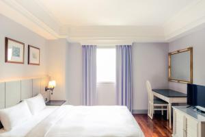 a hotel room with a bed and a desk at Rhyme&Time Hotel in Kaohsiung
