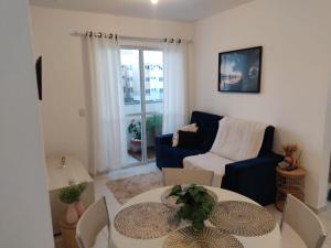 a living room with a blue couch and a table at Praia canavieiras in Florianópolis