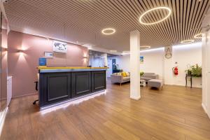 an office lobby with a reception counter and a couch at Grand Hotel Sénia - Paris Orly Airport in Orly