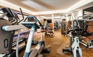 a gym with treadmills and machines in a room at Hotel Mondin in Ischgl