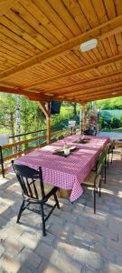 a picnic table with a pink and white checkered table cloth at Mali Raj in Beška +31 photos