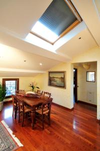 a dining room with a wooden table and a skylight at Hotel Stella in Modena