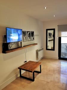 a living room with a table and a flat screen tv at UmanKuyen Aire y Agua in Mar del Plata